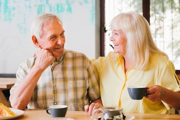 Pareja de ancianos bebiendo té y hablando animadamente