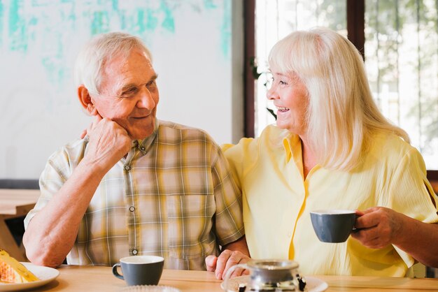 Pareja de ancianos bebiendo té y hablando animadamente