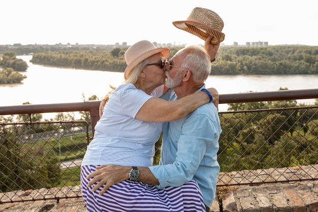 Pareja de ancianos besándose fuera de tiro medio