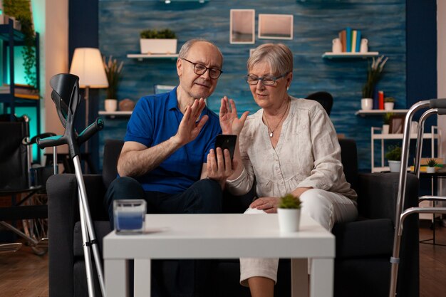 Pareja de ancianos casada con smartphone para videollamada