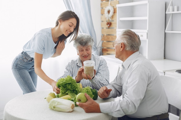 Pareja de ancianos en una cocina con joven nieta