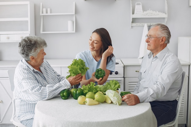 Pareja de ancianos en una cocina con joven nieta