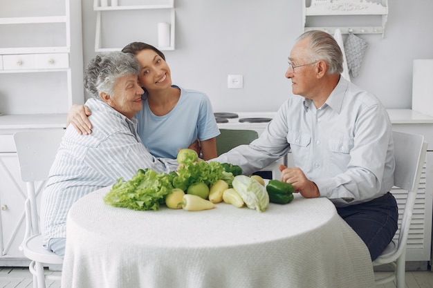 Pareja de ancianos en una cocina con joven nieta