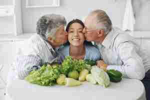 Foto gratuita pareja de ancianos en una cocina con joven nieta