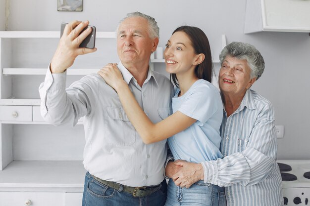 Pareja de ancianos en una cocina con joven nieta