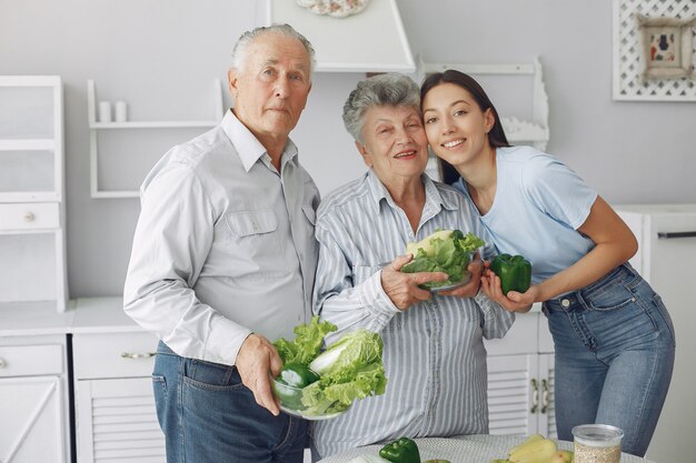 Pareja de ancianos en una cocina con joven nieta