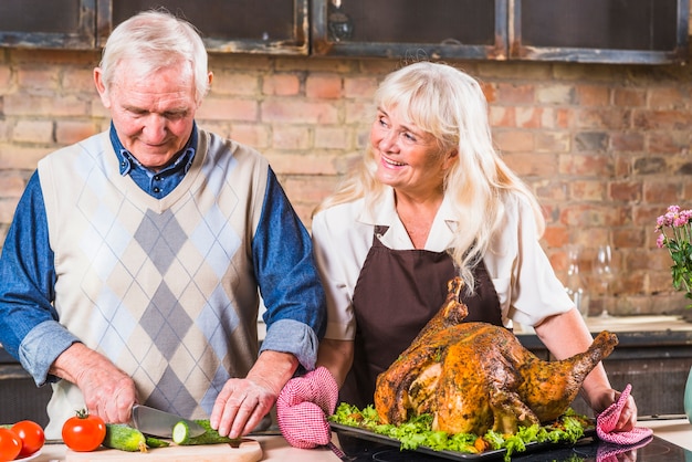 Foto gratuita pareja de ancianos cocinar pavo con verduras