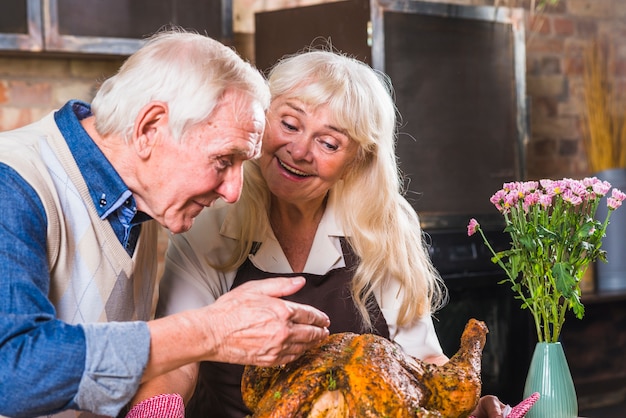 Pareja de ancianos cocinar pavo