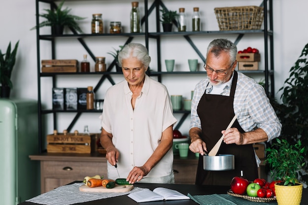 Foto gratuita una pareja de ancianos cocinar verduras en la cocina