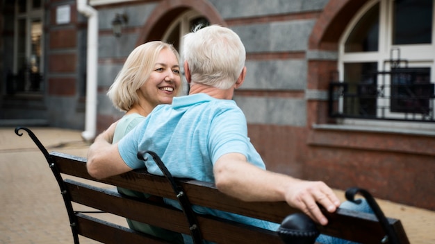 Pareja de ancianos disfrutando de su tiempo en un banco al aire libre