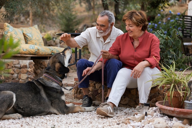 Pareja de ancianos disfrutando de la vida en casa en el campo con su perro