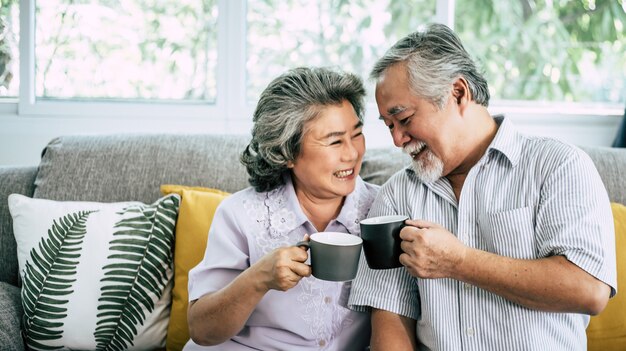 Pareja de ancianos hablando juntos y tomando café o leche