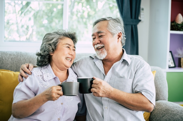 Pareja de ancianos hablando juntos y tomando café o leche