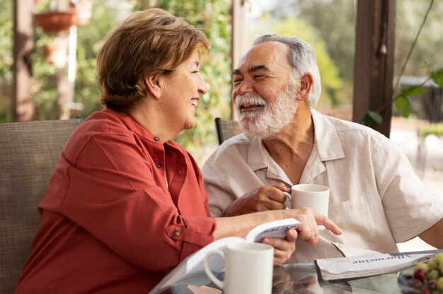 Pareja de ancianos leyendo juntos en su casa de campo