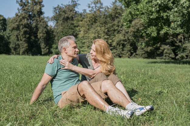 Pareja de ancianos sentados juntos en el césped