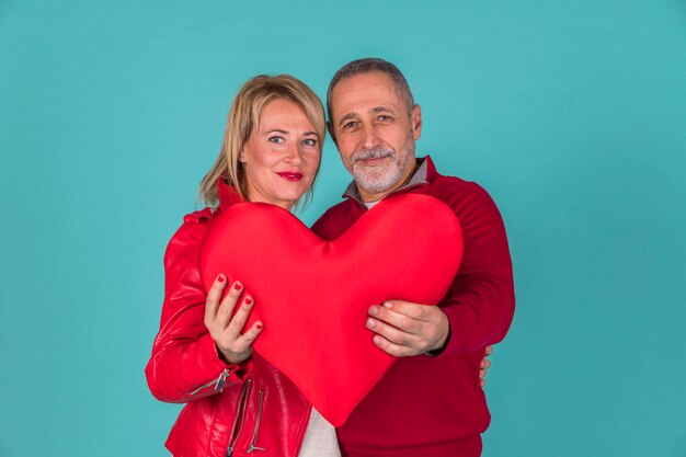 Pareja de ancianos con símbolo de juguete del corazón