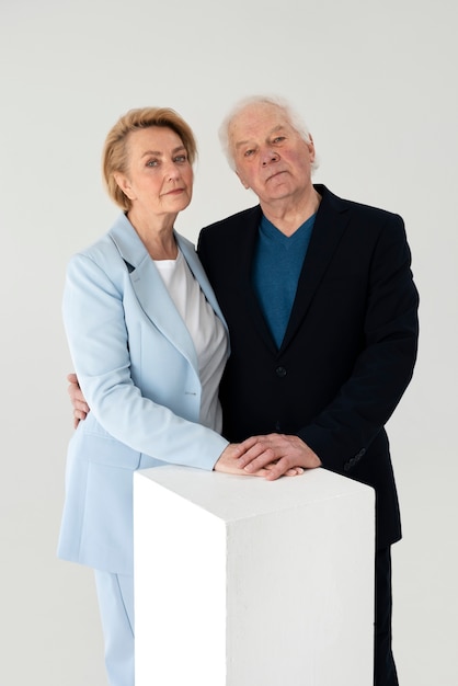 Pareja de ancianos de tiro medio posando en el estudio