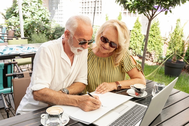 Pareja de ancianos tomando notas en agenda