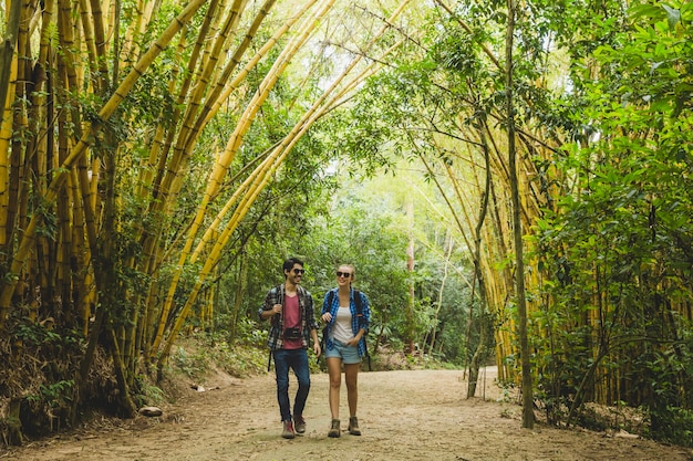 Pareja andando por bosque de bambú