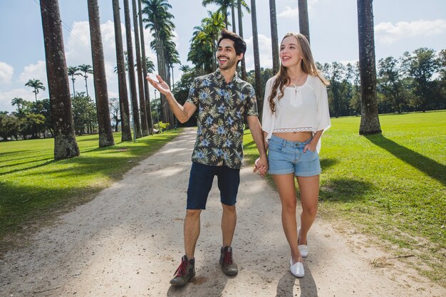 Pareja andando en camino de palmeras