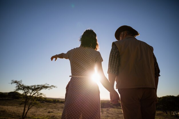 Pareja apuntando a distancia durante las vacaciones de safari