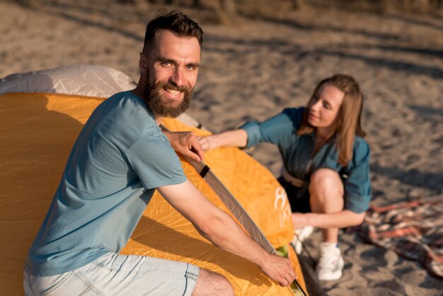 Pareja armando una carpa durante el día