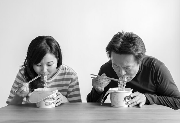 Pareja asiática comiendo fideos instantáneos