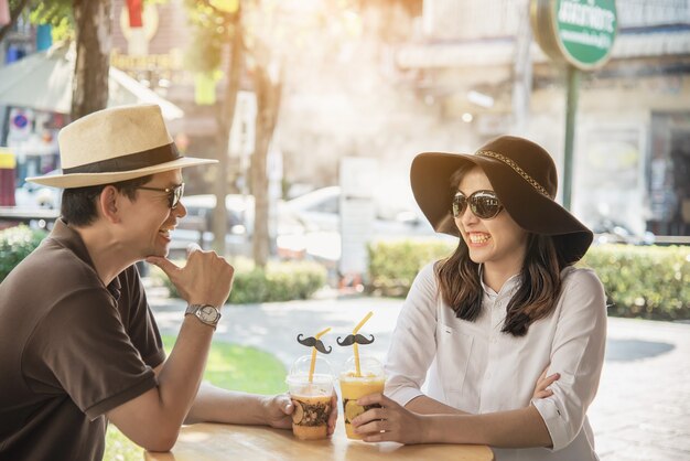 Pareja asiática disfruta de viajar sentado en la cafetería