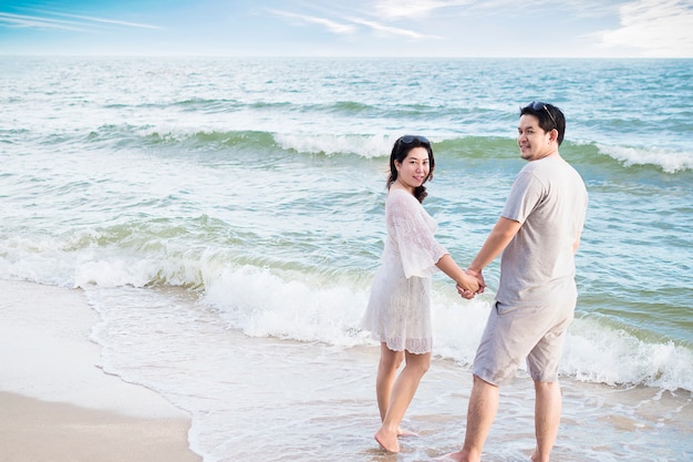 Foto gratuita pareja asiática en la playa