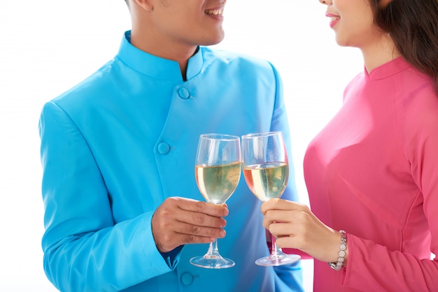 Pareja asiática recortada en traje tradicional disfrutando de vino