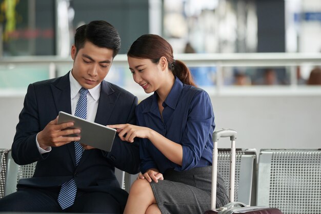 Pareja asiática usando tableta en el aeropuerto