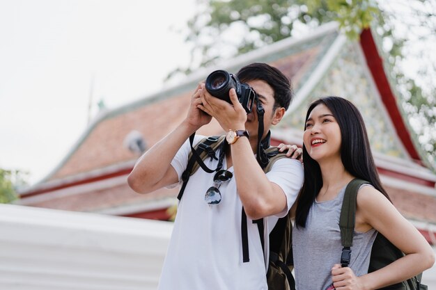 Pareja asiática de viajeros que usa una cámara para tomar una foto mientras pasa un viaje de vacaciones a Bangkok, Tailandia