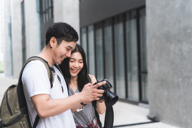 Pareja asiática de viajeros que usa una cámara para tomar una foto mientras pasa un viaje de vacaciones a pekín, china