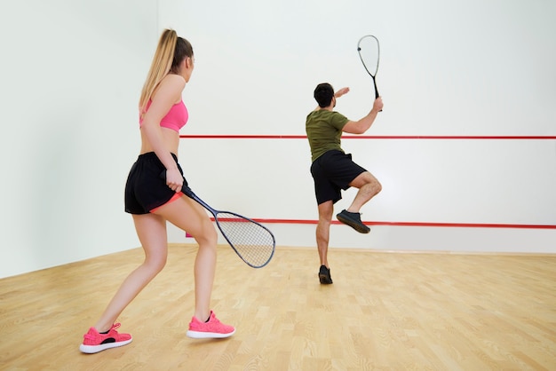 Pareja atlética jugando squash juntos