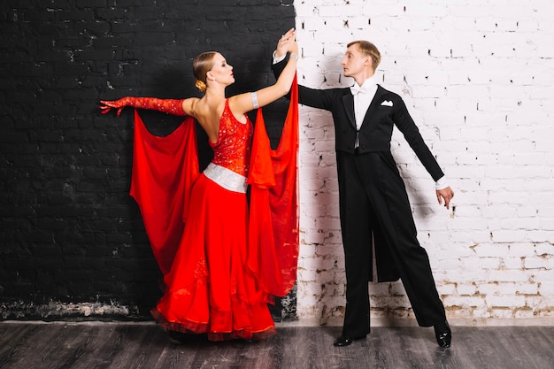 Foto gratuita pareja bailando cerca de la pared en blanco y negro