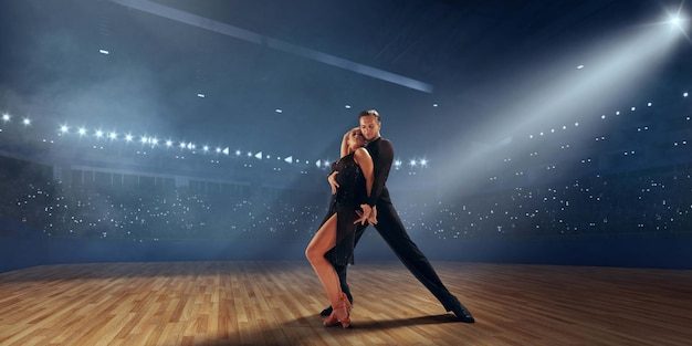 Foto gratuita pareja de bailarines realizan bailes latinos en un gran escenario profesional