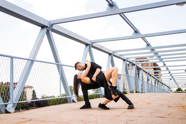 Foto gratuita pareja de baile romántico de tango actuando en el puente