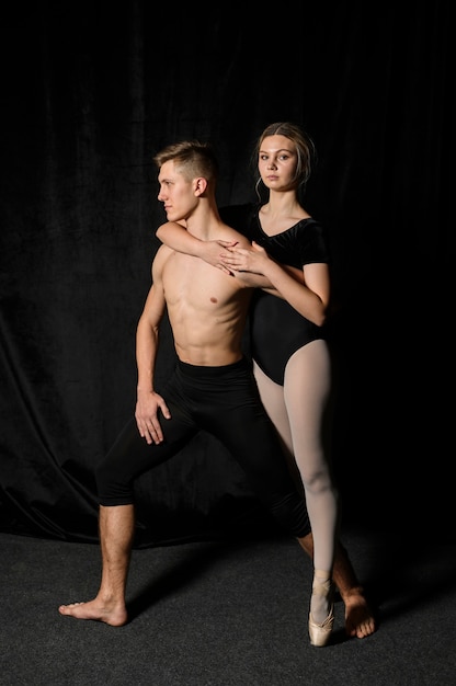 Pareja de ballet posando en medias y leotardo