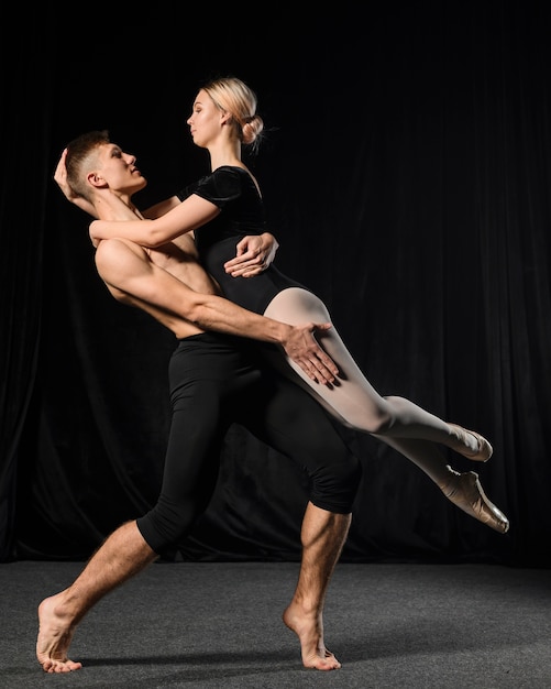 Pareja de ballet posando mientras se abraza