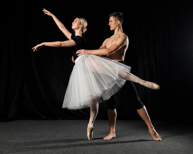 Pareja de ballet posando en tutú y medias