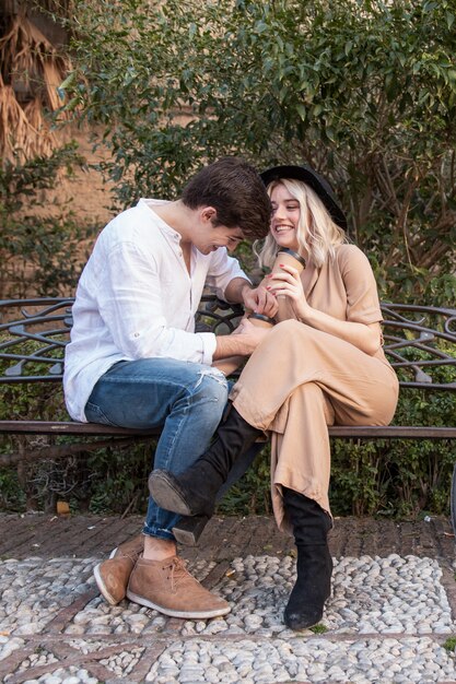 Foto gratuita pareja en el banquillo sonriendo