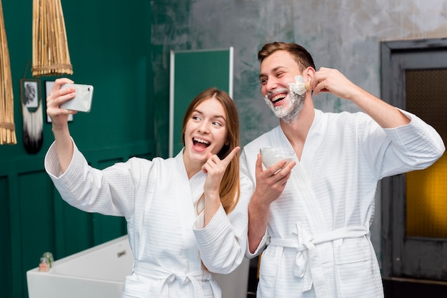 Pareja en batas de baño tomando una selfie