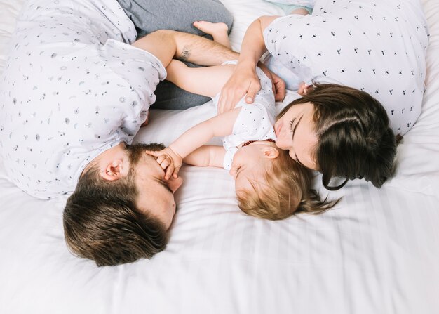 Pareja con bebé en la cama