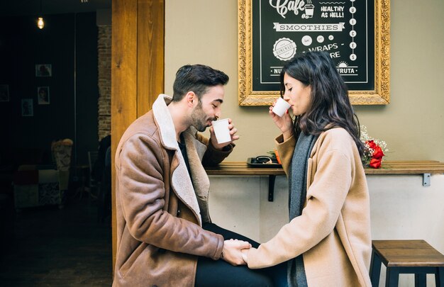 Pareja bebiendo en el café al aire libre