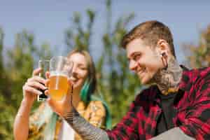 Foto gratuita pareja bebiendo cerveza artesana al aire libre