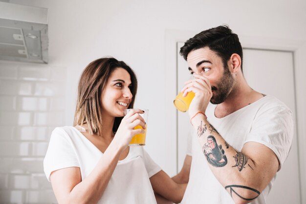 Pareja bebiendo jugo en la cocina