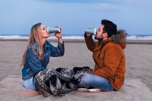 Pareja bebiendo en la playa