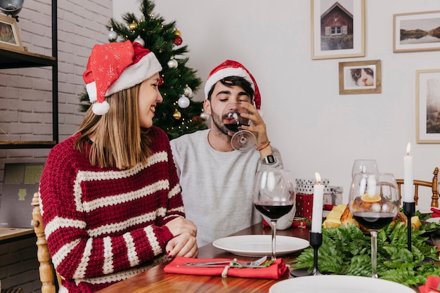 Pareja bebiendo vino en cena de navidad