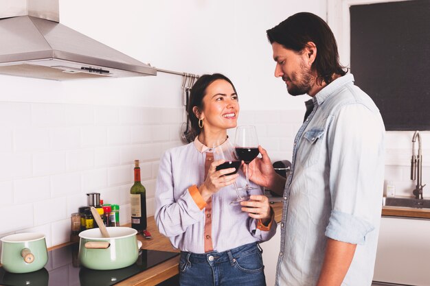 Pareja bebiendo vino en la cocina