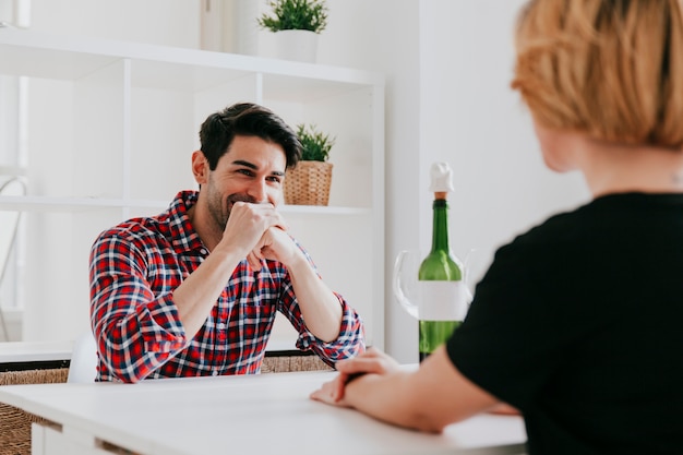 Foto gratuita pareja bebiendo vino y hablando en mesa